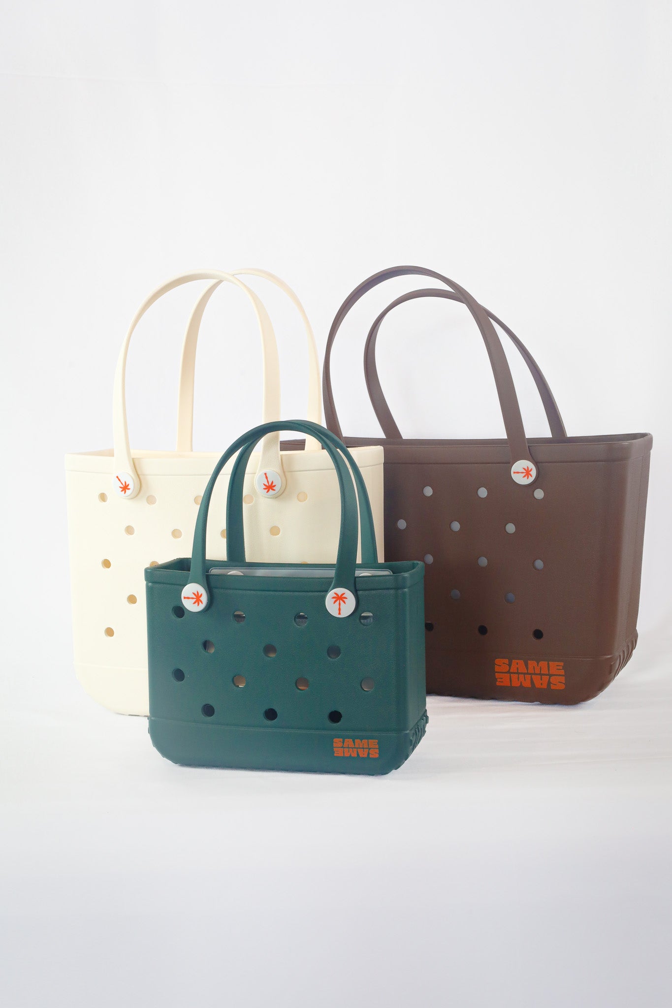 Three handbags in different colors on a white background